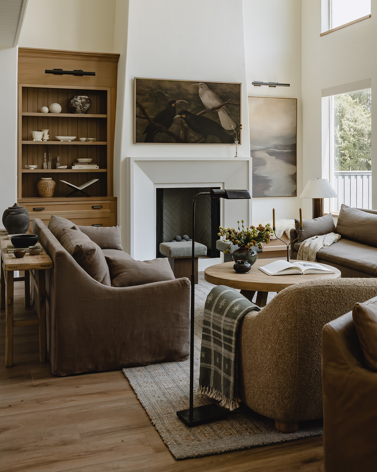 Wide view of living room with fireplace, built-ins and layered seating