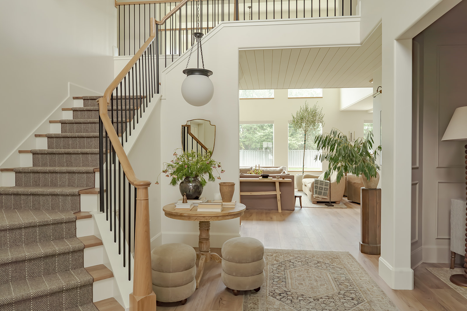 Entry foyer with staircase, globe pendant, and antique console