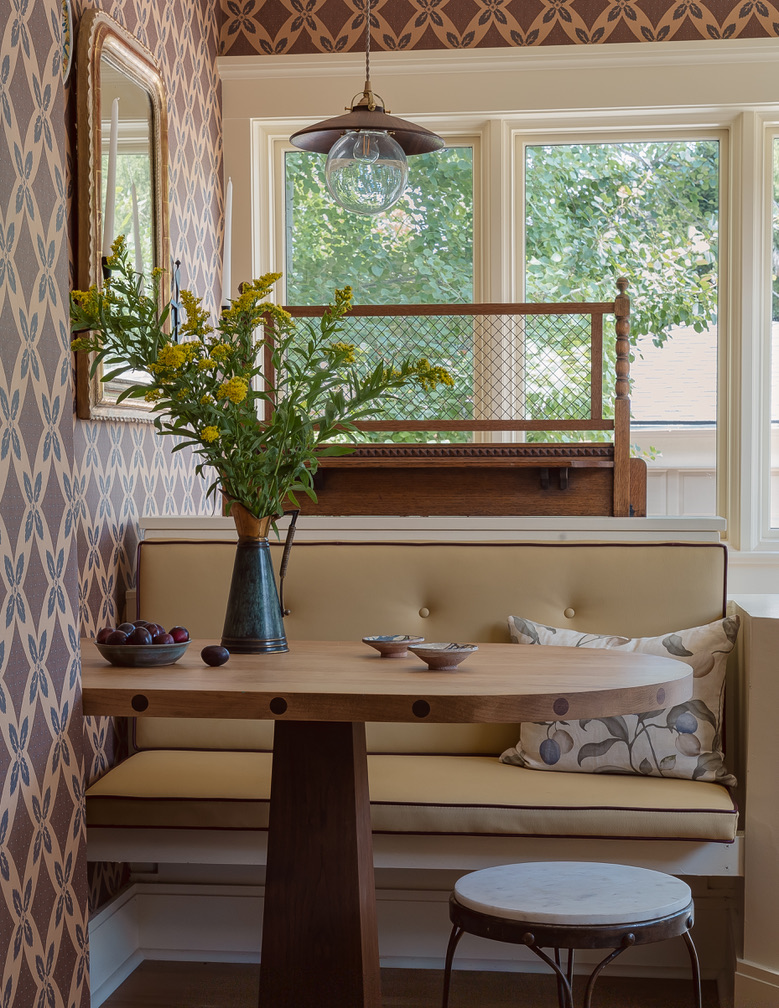 Breakfast nook banquette with vintage mirror and garden view