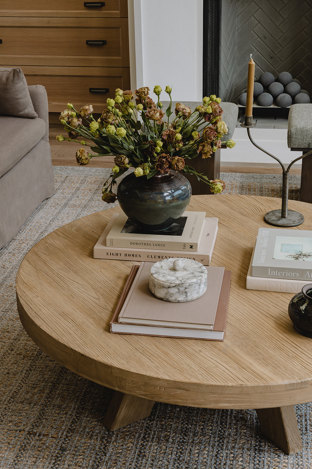 Round oak coffee table with flowers, books and marble box